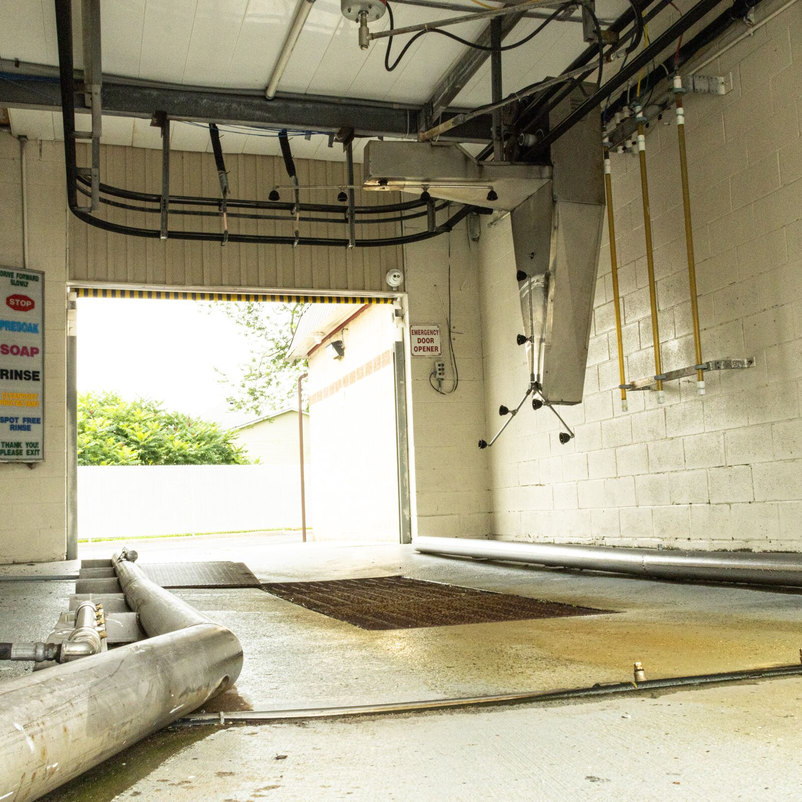 Overhead equipment inside a self-serve wash bay