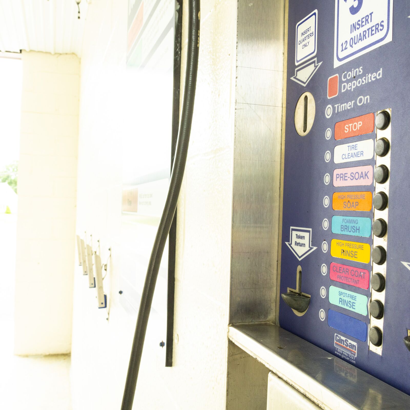 Wall-mounted equipment panel inside a wash bay